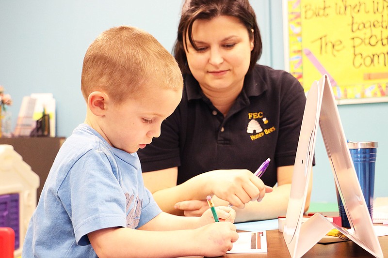 A young boy draws shapes as part of preschool screening at Fulton Education Center Monday afternoon.