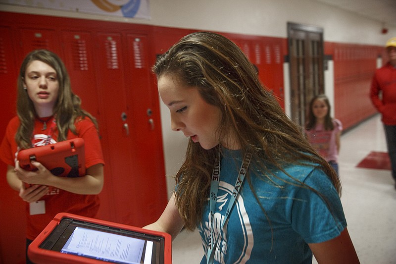 Student ambassadors Hanna Watson, right, and Mikayla Thomas take a family on a tour at Simonsen Ninth Grade Center on Tuesday during Parochial Night where incoming students tour the school and seek placement in their respective academies.