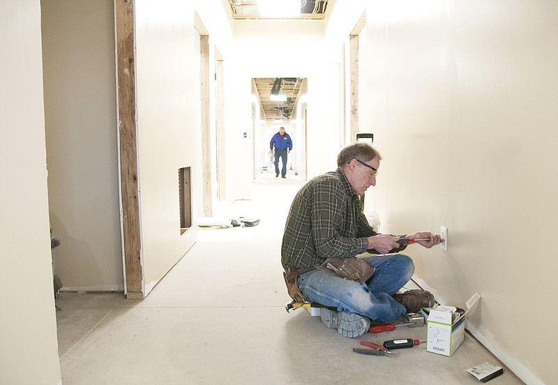 Lewis Beaty, electrician, installs an outlet inside the new Fulton animal shelter last week. Beaty volunteered his electrical services for the animal shelter project.