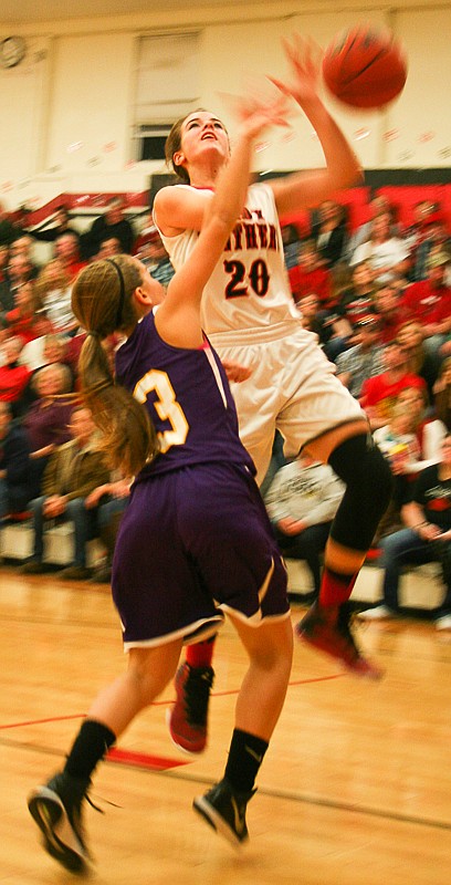 Prairie Home sophomore Rachel Distler (20) goes up for a shot in Friday's game, but an Otterville defender knocks the ball away. The Lady Panthers were victorious, 63-31.