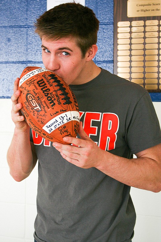 California senior Walker Borghardt kisses a football after signing his national letter of intent last week to play at Baker University in Baldwin City, Kansas. Borghardt said his love for football blossomed in high school.