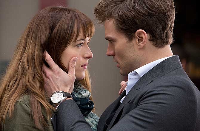 In this image released by Universal Pictures and Focus Features, Dakota Johnson, left, and Jamie Dornan appear in a scene from "Fifty Shades of Grey." 