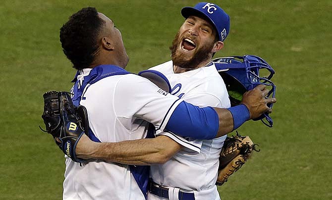 In this Wednesday, Oct. 15, 2014, file photo Kansas City Royals relief pitcher Greg Holland and catcher Salvador Perez celebrate after defeating the Baltimore Orioles 2-1 in Game 4 of the American League baseball championship series in Kansas City, Mo. The Royals and Holland avoided salary arbitration when they agreed to an $8.25 million, one-year contract before their hearing. Under the terms of Friday's, Feb. 13, 2015, agreement Holland will receive a $100,000 assignment bonus if he's traded. 
