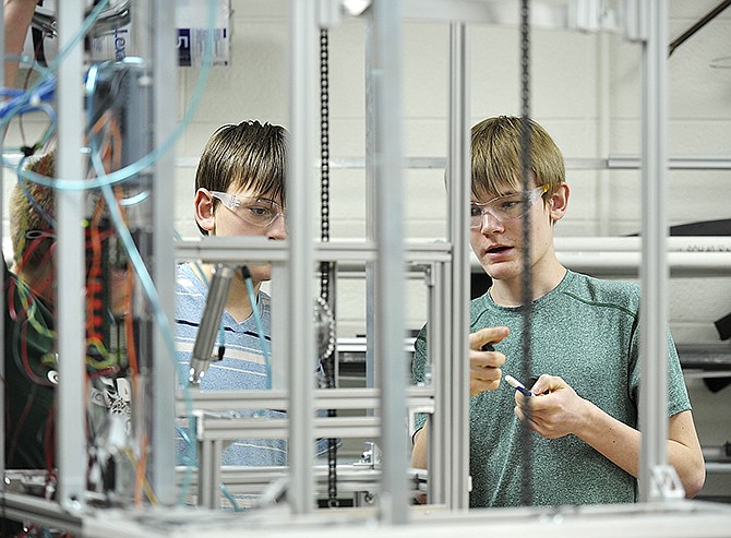Skyler Winkelman, 13, left, and his brother, Tanner, discuss options while working on a robot. They are part of a four-person team working on their FIRST Robotics Competition robot in a lab at Lincoln University. Their robot has to be able to lift a plastic container and stack it atop another. 
