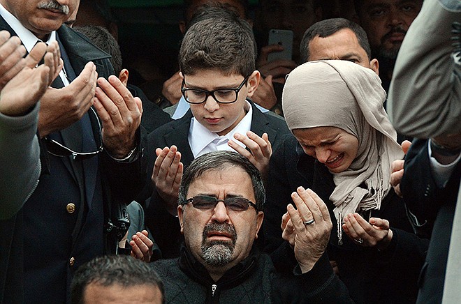 Namee Barakat, center, watches during funeral services for his son, Deah Shaddy Barakat, Thursday, in Wendell, North Carolina.  Barakat, 23, his wife, Yusor Mohammad Abu-Salha, 21, and her sister Razan Mohammad Abu-Salha, 19, were found dead Tuesday at their home near the University of North Carolina.