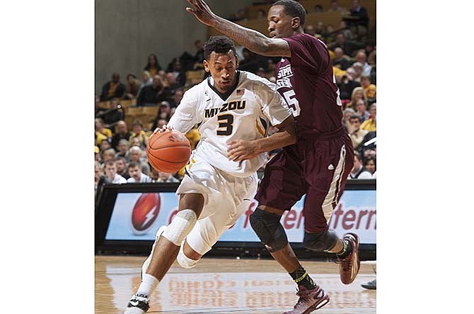 Missouri's Johnathan Williams III, left, drives past Mississippi State's Roquez Johnson, right, during the first half of an NCAA college basketball game Saturday, Feb. 14, 2015, in Columbia, Mo. 