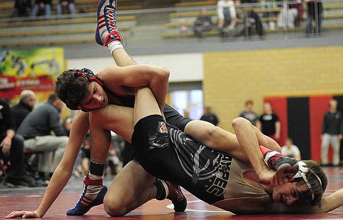 Jefferson City's Peter Kuster (left) works on Raymore-Peculiar's Miles Robinson in Saturday's 113-pound championship match in the district tournament at Fleming Fieldhouse in Jefferson City.