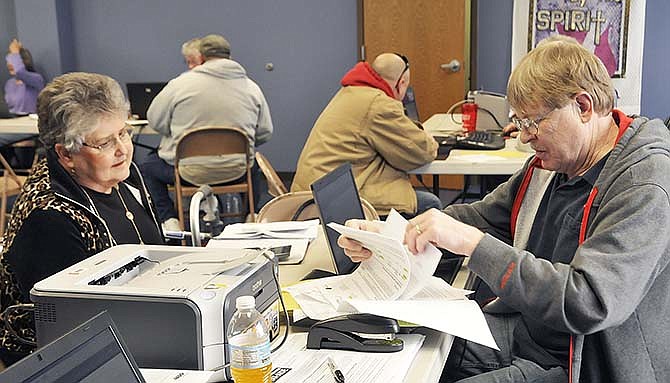 Bill Price, right, one of several volunteers from the Jefferson City Chapter of the AARP, helps Cynthia Buser with her income tax paperwork Friday. AARP is offering their services for free to seniors from 9 a.m. to noon, each Tuesday and Friday until April 14. They will be located in the back building at Faith Lutheran Church on Industrial Drive.