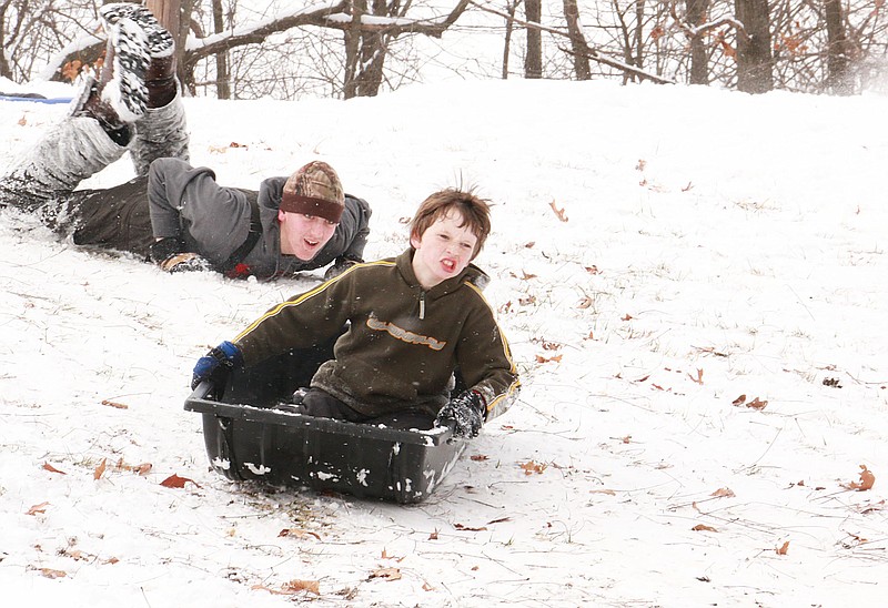 Jesse Peterson braces himself and holds on tightly to his sled as he slides down a snow-covered hill at Memorial Park in Fulton Monday afternoon.