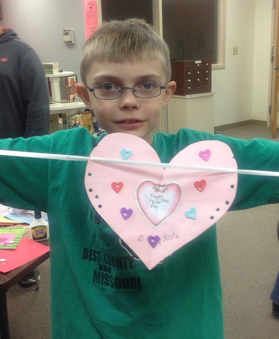 Dakota Kuester shows off the Valentine he made at the Helping Hands 4-H meeting. The 4-H group has a tradition of making Valentines for local senior citizens and friends of 4-H.