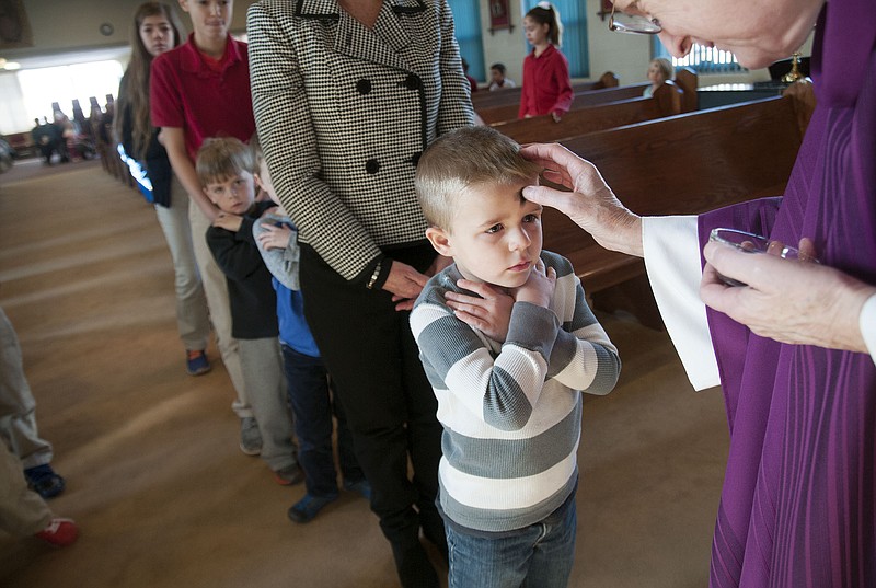 A young St. Peter Catholic School student receives ashes from Father Frank Bussmann inside the church on Ash Wednesday. The religious event kicks off the Lenten season, a six week period in preparation for Easter Sunday on April 5. Lent also serves as a time of repentance for Christians, and it's customary for them to give up something in reflection of Jesus' sacrifice of his life. "(Ashes are) a sign we want to repent," Bussmann said to the congregation gathered for 8:15 a.m. mass Wednesday. "They're a sign we want to turn our lives around."