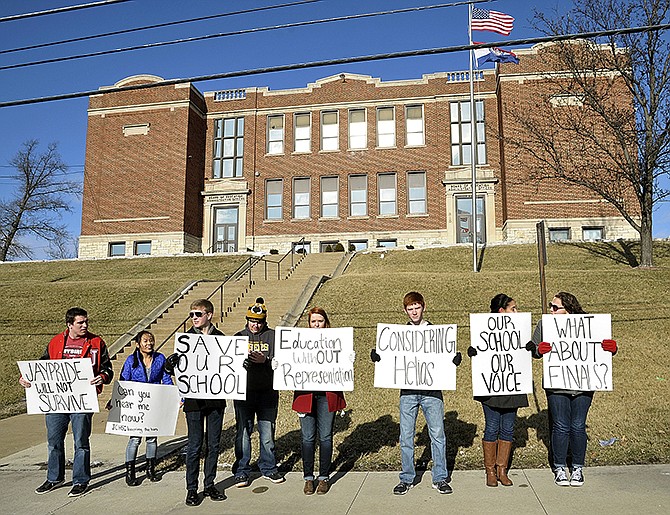 Thomas Hatfield, in stocking cap, a student journalist for the Red and Black, interviews fellow Jefferson City High School students who held up signs Wednesday as they stood outside the JCPS administration building to protest a proposed 10-block schedule for the high school.