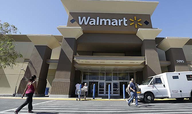 In this Sept. 19, 2013 file photo, customers walk outside of a Wal-mart store in San Jose, Calif. Wal-Mart Stores Inc.