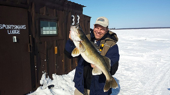 Joe Henry, the executive director of Lake of the Woods Tourism Bureau, holds a 31.5-inch, 12-pound Lake of the Woods walleye.