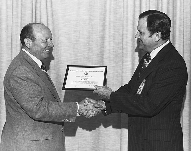 James W. Bass, left, receives a 30-year service award on March 2, 1979 from fellow NASA employee Dr. William R. Lucas, director of the Marshall Space Flight Center from 1974 to 1986. 
