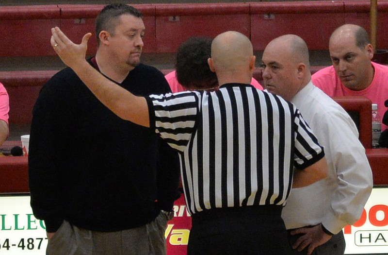 A referee talks to Riverdale coach Cory Barrett (left) and Smyrna coach Shawn Middleton during Saturday's game in Murfreesboro, Tenn.