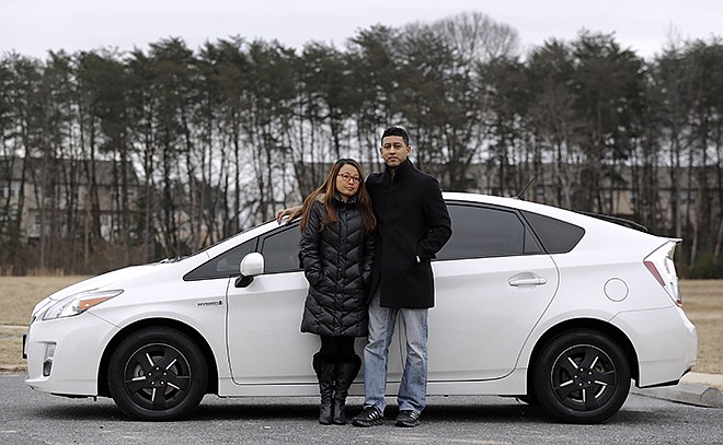 Eri and John Castro pose Feb. 14 in front of their 2011 Toyota Prius in Glen Burnie, Maryland. The Castros bought the pre-owned car last year, only to find out after they got it home that it was under recall because it could stall without warning.