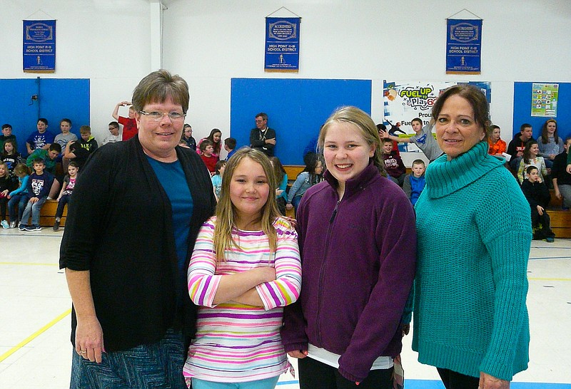 High Point R-III Spelling Bee Champions are all smiles, from left, master of ceremonies Debra Hartman, elementary champion Jillian Schmidt, middle school champion Kaylena Riggs, and organizer Galen Maples.