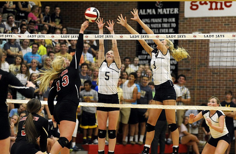 Helias setter Ashley Dudenhoeffer (5) and middle hitter Erica Haslag (3) throw up a block as Jefferson City outside hitter Mary Vandelicht takes a swing during a match this season at Fleming Fieldhouse. Dudenhoeffer and Haslag were recently named All-Americans by PrepVolleyball.com.