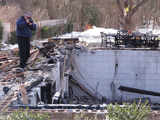 Fire investigator John Lightbody photographs the remains of a Stafford Township New Jersey home on Wednesday, a day after the house was leveled by a natural gas explosion. One of the 15 people injured in the blast remained in critical condition on Wednesday. 