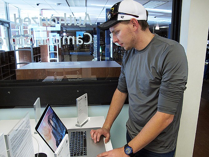 Zak Holland opens up a computer at a store on the Northern Arizona University campus in Flagstaff  Wednesday. Much of the region was experiencing an Internet and phone outage that was linked to vandalism of a fiber-optic line. 