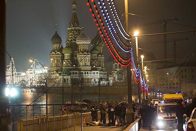 Russian police investigate the body of Boris Nemtsov, a former Russian deputy prime minister and opposition leader at Red Square with St. Basil Cathidral in the background in Moscow, Russia, Saturday, Feb. 28, 2015. Russia's Interior Ministry says Boris Nemtsov, a leading opposition figure and former deputy prime minister, has been shot and killed near the Kremlin. Nemtsov, a sharp critic of President Vladimir Putin, was killed early Saturday. His death comes just a day before a major opposition rally in Moscow.
