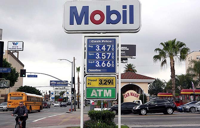 A cyclist rides by a sign at a gas station in Los Angeles posting the latest gas prices on Friday, Feb. 27, 2015. Gas prices in California soared overnight as a result of a combination of supply-and-demand factors worsened by the shutdown of two refineries that produce a combined 16 percent of the state's gasoline.