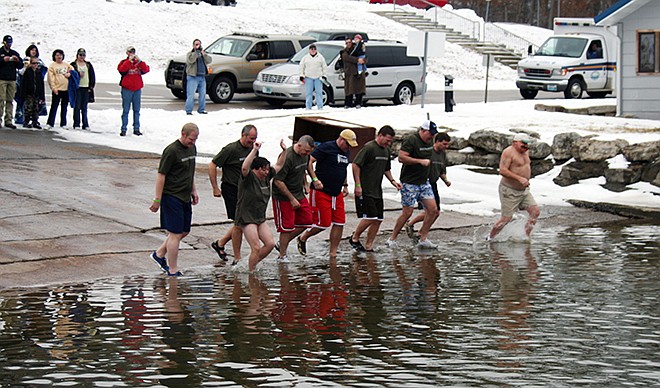 Super Plunger and Jefferson City High School math teacher Curt Yaeger, fourth from the right, takes one of 24 hourly-dips before kicking off the annual Polar Plunge, which raised thousands of dollars for Special Olympics Missouri.