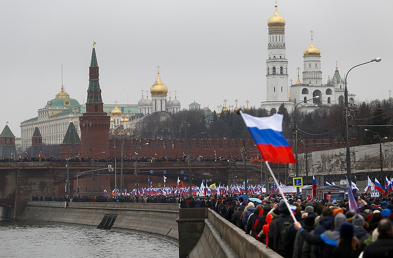 People with Russian national flags march Sunday near the Kremlin in memory of opposition leader Boris Nemtsov, who was gunned down on Friday. Thousands converged Sunday in central Moscow to mourn veteran liberal politician Boris Nemtsov.