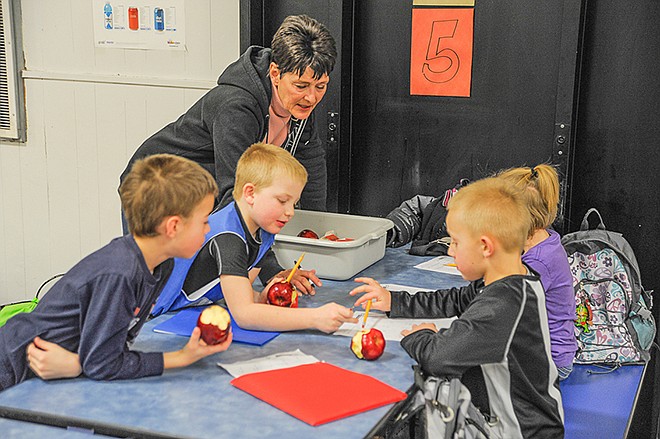 Jackson Hackett watches as Landen Hentges talks to Justin Seaver and Ella Stanley about their homework. The group is part of about a dozen students who stay at Russellville Elementary School's new after-school care program run by Gail Cartee.