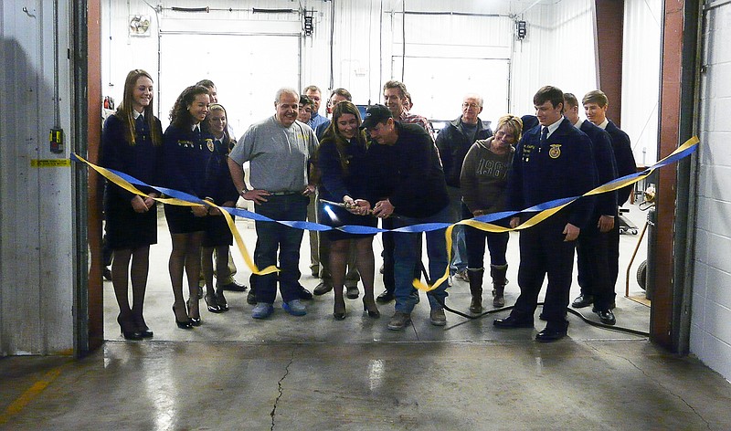 FFA President Madelyn Jobe and California School Board President Jay VanDieren, center, surrounded by the CHS FFA Advisors, officers and school board members torch the ribbon to officially dedicate the new agricultural building Thursday, Feb. 19.