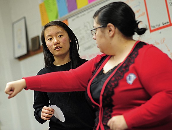 Jefferson City High School speech and debate team assistant coach Kristi Moore, right, gives ninth-grader Katie Liu some pointers while working with her on her Humorous Interpretation presentation during an after school practice session for the team on Wednesday.