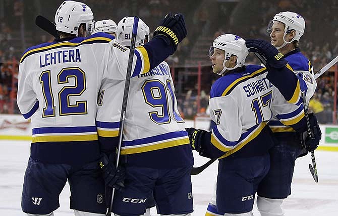 St. Louis Blues' Jori Lehtera (12), of Finland, Vladimir Tarasenko (91), of Russia, Jaden Schwartz (17) and Jay Bouwmeester (19) celebrate after Schwartz's goal during the first period of an NHL hockey game against the Philadelphia Flyers, Thursday, March 5, 2015, in Philadelphia. 