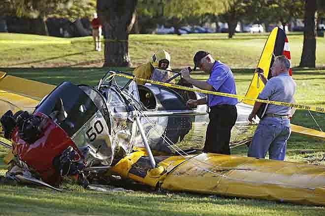 Officials work on the scene of a vintage airplane that crash-landed Thursday on the Penmar Golf Course in the Venice area of Los Angeles. Harrison Ford crash-landed the airplane shortly after taking off from a nearby airport and reporting engine problems.