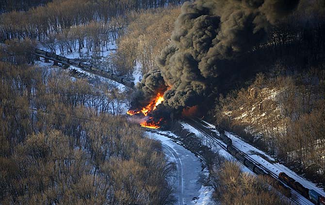 Smoke and flames erupt from the scene of a train derailment Thursday, March 5, 2015, near Galena, Ill. A BNSF Railway freight train loaded with crude oil derailed around 1:20 p.m. in a rural area where the Galena River meets the Mississippi, said Jo Daviess County Sheriff's Sgt. Mike Moser. 