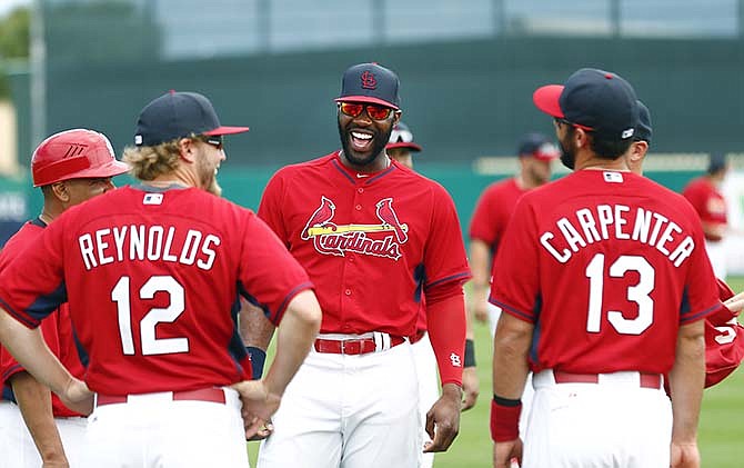 St. Louis Cardinals Jason hey ward, center laughs with teammates Mark Reynolds (12) and Matt Carpenter (13) before a spring training baseball game against the Miami Marlins Sunday, March 8, 2015, in Jupiter, Fla.