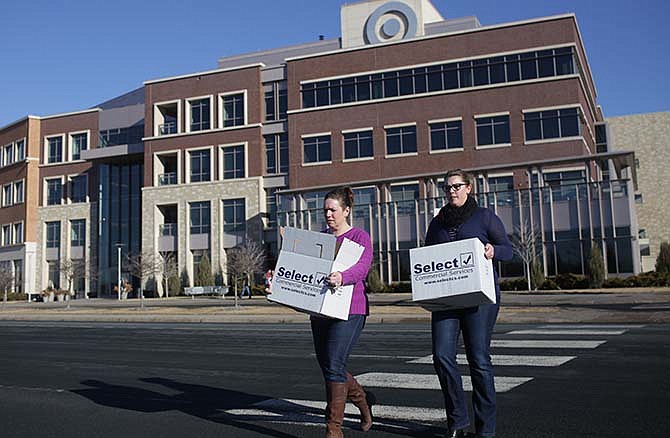 Two Target employees leave the Brooklyn Park Target campus Tuesday, March 10, 2015 carrying boxes of belongings. They said they were affected by the layoffs. Target Corp. said Tuesday it is laying off 1,700 workers and eliminating another 1,400 unfilled positions as part of a restructuring aimed at saving $2 billion over the next two years. (AP Photo/Star Tribune, David Denney)