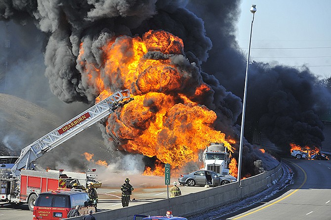 Firefighters watch as a tanker truck and at least one car, right, burn, shutting down a stretch Interstate 94, Wednesday in Dearborn, Michigan. Michigan Police Lt. Michael Shaw said there were no reports of injuries. He says the truck was believed to have been hauling petroleum. 
