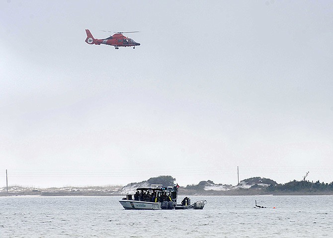 A U.S. Coast Guard helicopter flies over Santa Rosa Sound near Navarre, Florida, Wednesday as search crews and divers look for the crash site of a Army helicopter that went down Tuesday evening with 11 service members aboard.