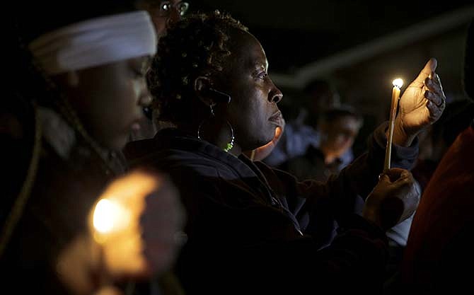 People take part in a candlelight vigil Thursday, March 12, 2015, in Ferguson, Mo. Two police officers were shot early Thursday morning in front of the Ferguson Police Department during a protest following the resignation of the city's police chief in the wake of a U.S. Justice Department report. 