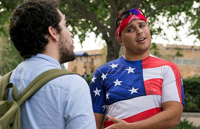 University of California, Irvine student Tim Dicorato, left, debates flag supporter Robert McLogan, 27, right, in Anteater Plaza Tuesday, March 11, 2015 in Irvine, Calif. Campus officials on Tuesday received "a viable threat of violence associated with the recent controversy," and while the threat wasn't specific it was being taken seriously and campus police had increased security and were asking students to report suspicious activities, according to a UC Irvine statement. 