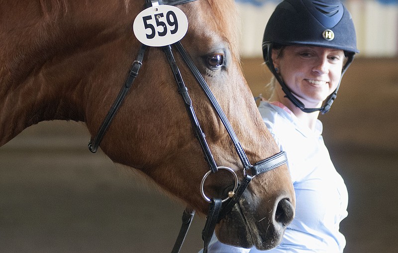 Colleen Rull of St. Louis smiles back at her horse Rapson after riding in the William Woods University Completely Relaxed Spring School Dressage Show on Saturday inside the Rowland Applied Riding Arena. 
