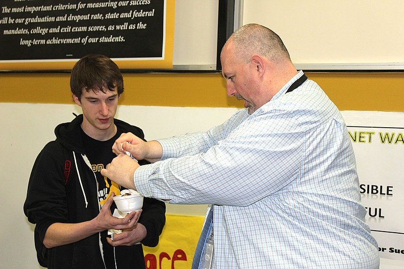 Fulton High School Principal Jason Whitt tops a student's sundae with whipped cream Thursday afternoon. The ice cream social was part of the school's annual Academic Week to recognize students who mantain a 3.75 GPA or higher for three or more semesters.