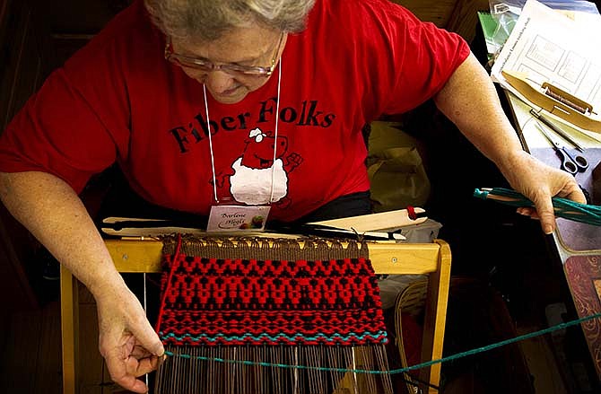 Darlene Megli, a member of a boundweave class, works on a loom to create the tight weaves used in saddle blankets Saturday morning during the Fiber Retreat at Lincoln University's Busby Farms south of Jefferson City.