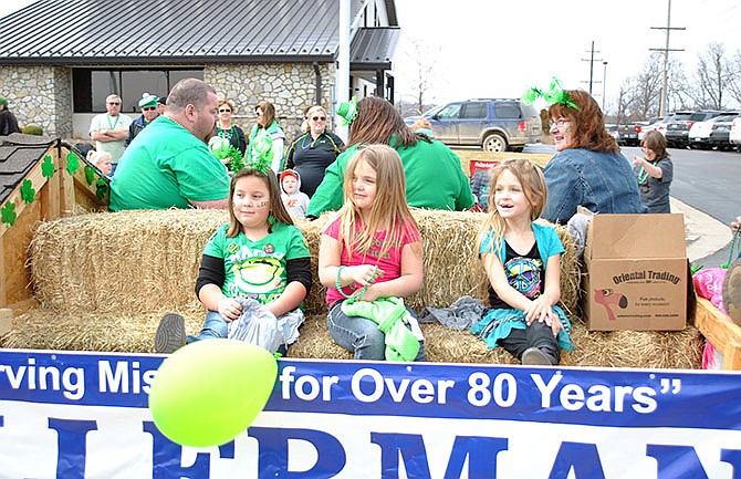 Once candy was gone, children enjoyed cruising down Bagnell Dam Boulevard in the St. Patrick's Day Parade, like these girls aboard the Ellerman Construction float.