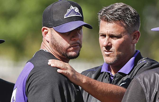 Colorado Rockies relief pitcher Rafael Betancourt is examined by trainer Keith Dugger after Betancourt was struck by a line drive while pitching against the Kansas City Royals in a spring training baseball game Thursday, March 19, 2015, in Surprise, Ariz. Betancourt left the game.