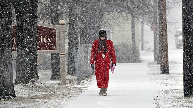 Although spring officially began Friday, a woman braves a snowstorm that passed through the area earlier in the day and walks along East Juniper Street in Hazleton, Pennsylvania.