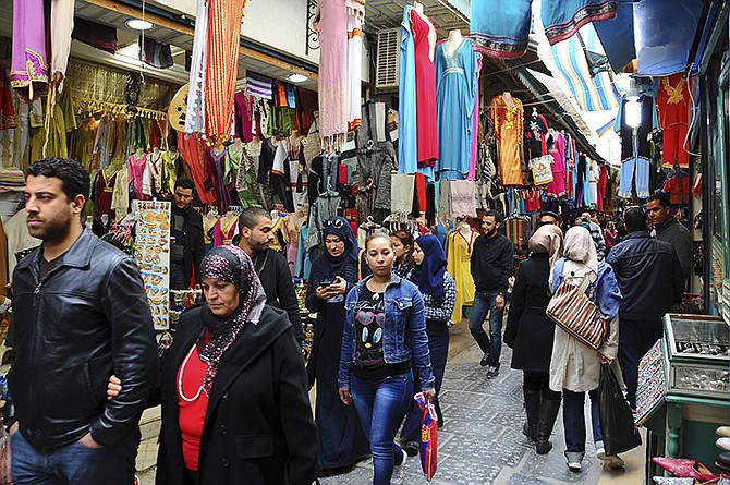 Tunisians walk in a market in Tunis on Friday. Yet another terror attack is taking its toll on tourism, with cruise companies canceling stops in Tunisia following the killings of 21 people. 
