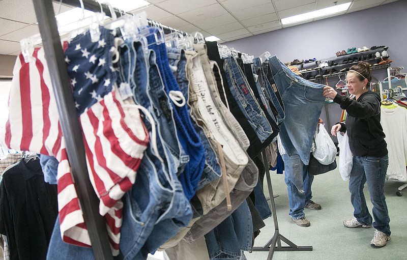 Chasity Waage of Auxvasse looks through jeans at the Kingdom Projects, Inc. (KPI) pound sale on Saturday.