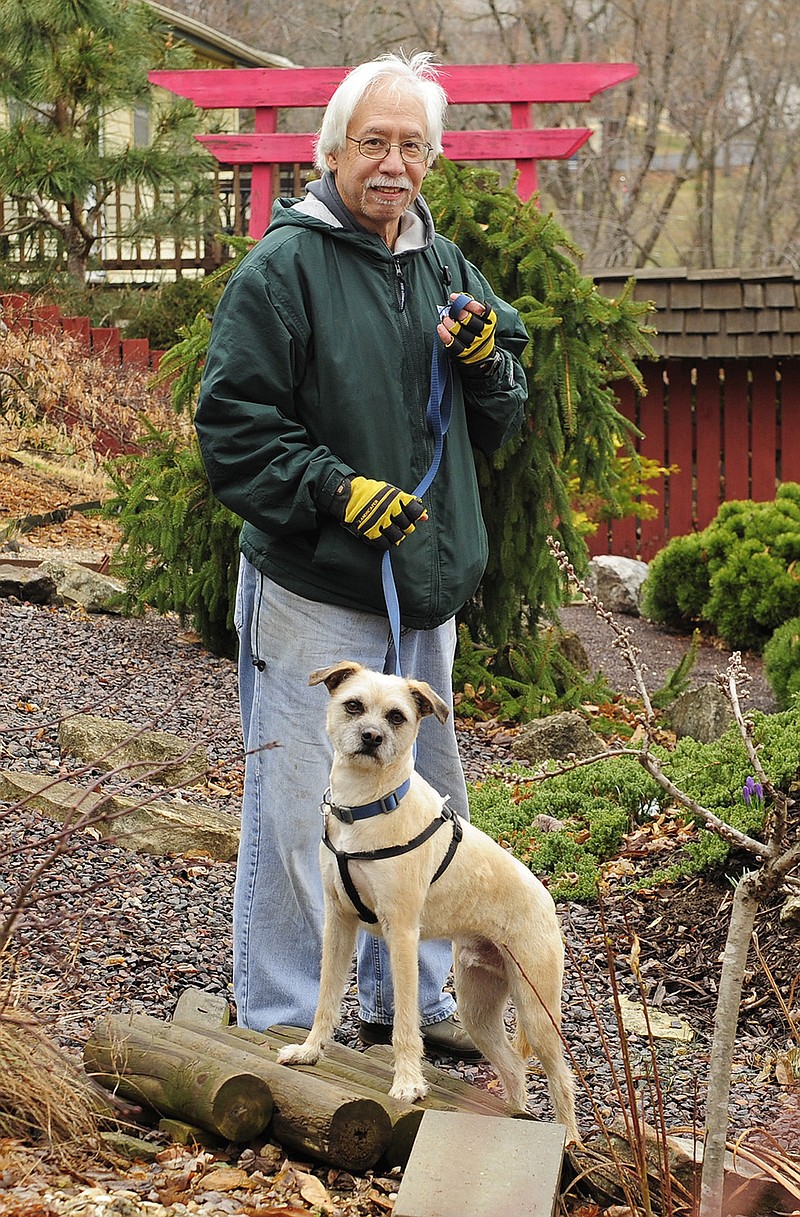William Zimmerman pauses with his dog Dante along the graveled path running through his backyard.
